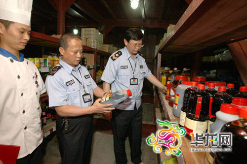 食品药品监督局执法人员在南滨路某餐馆厨房检查食品添加剂使用情况